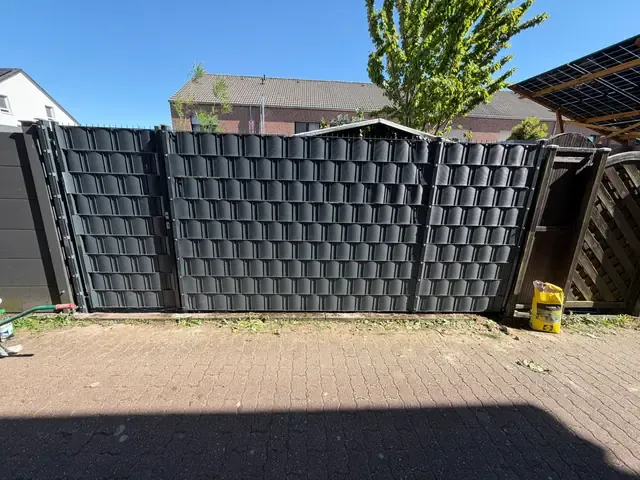 Neue Doppelstabmattenanlage mit anthrazitfarbenen Sichtschutzstreifen an derselben Grundstücksgrenze in Viersen-Dülken